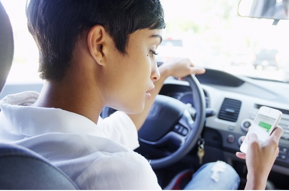 woman in a car texting on phone