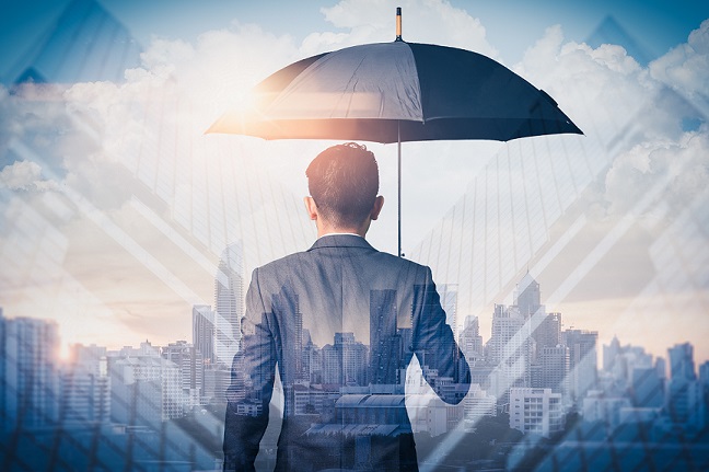 Man looking at a city skyline holding an umbrella 