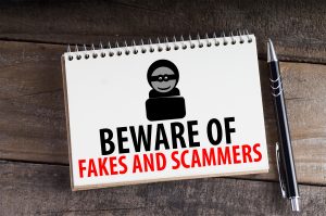 Notepad of paper with theif icon and the words beware of fakes and scammers