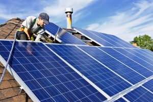 man on roof installing solar panels